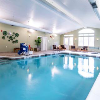 An inviting indoor swimming pool with seating and natural lighting.