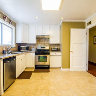 A modern kitchen interior featuring white cabinets and stainless steel appliances.