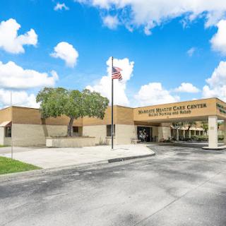 A medical center featuring a welcoming exterior and an American flag, surrounded by landscaped areas.