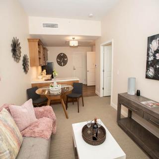 A cozy apartment living room with modern decor and an adjoining dining area.