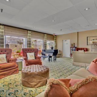 A cozy living room with ample seating and a piano.