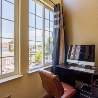 A cozy home office setup with a computer on a desk by the window, allowing plenty of natural light.