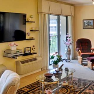 A cozy living room with a modern interior design, featuring a large television, comfortable seating, and decorative elements.