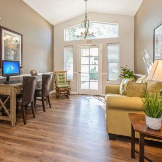 A cozy living room and home office space with abundant natural light and stylish furnishings.