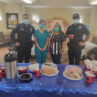 Community members and police officers come together for a celebration, enjoying snacks and refreshments.