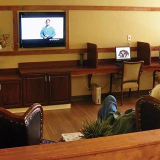 A cozy room with a television and computer desk setup.