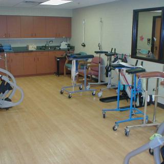 A rehabilitation room equipped with various exercise machines and therapy equipment.