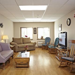 A cozy living room with sofas, chairs, and a television.