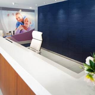 A modern reception area featuring a sleek desk and comfortable seating, designed to create a welcoming atmosphere.
