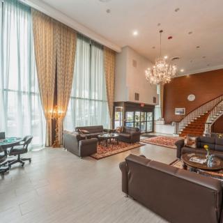 A luxurious hotel lobby featuring elegant furniture, a grand chandelier, and an impressive staircase.