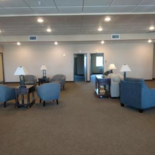 A spacious lounge area with comfortable seating and tables.