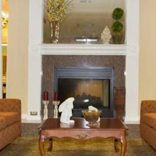 A cozy living room with a central fireplace, flanked by two sofas and a decorative coffee table.