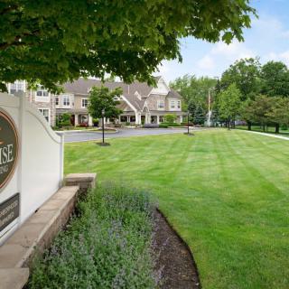 A well-maintained lawn and greenery in front of a building with a decorative sign.