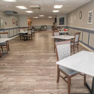 A spacious and modern dining room featuring empty tables and chairs, ready for guests.