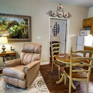 A cozy living room with a recliner and dining area connected to a small kitchen.