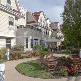 A scenic view of a residential building with outdoor seating and landscaped gardens.