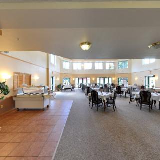A spacious dining room with neatly arranged tables and a buffet area.