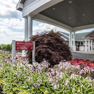Beautifully landscaped entrance with colorful flowers and a welcoming building.