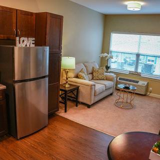 A cozy and modern apartment with a combined kitchen and living room area.