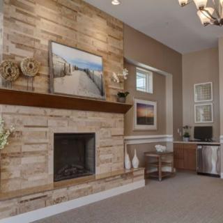 A cozy living room with a stone fireplace and modern decor.