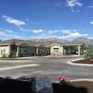 A picturesque view of a building with mountains in the background under a clear blue sky.