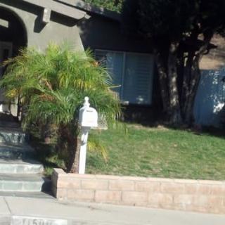 A suburban house with a mailbox and a grassy front yard.