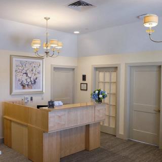 A reception desk in an office setting with warm lighting and neutral decor.