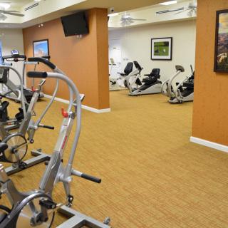 An indoor gym with various exercise equipment, including stationary bikes.