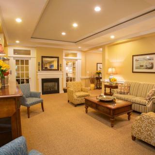 A cozy and warmly lit living room with comfortable seating, a fireplace, and elegant decor.