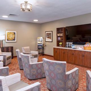 A comfortable waiting room with chairs arranged in a circle, a television, and a coffee station.