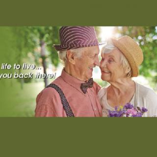 A beautiful moment shared between an elderly couple, celebrating love and companionship in a serene outdoor setting.