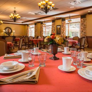 An elegantly set dining table in a warmly decorated restaurant.