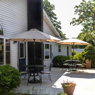 A sunny patio area with tables and umbrellas for outdoor seating.