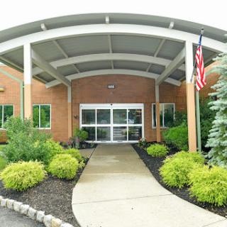 The inviting entrance to a modern building surrounded by well-maintained landscaping.