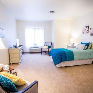 A bright and modern bedroom with stylish decor, featuring a comfortable bed and seating area.