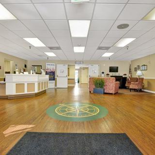 A spacious and well-lit reception area with seating and a front desk.