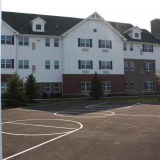 A three-story residential building with a parking area in front.