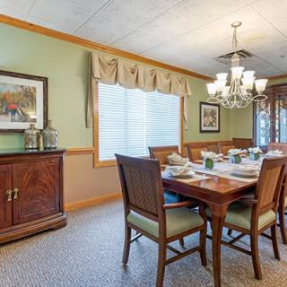 A classic dining room setup with a wooden table, chairs, and a chandelier.