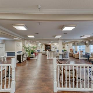 A spacious, well-lit interior room with wooden flooring and various furnishings.