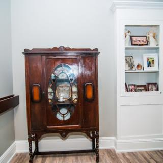 A beautifully crafted vintage cabinet with intricate details and glass accents, showcasing a blend of elegance and nostalgia in an interior setting.