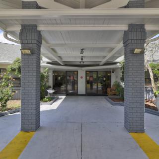 The image shows the entrance to a building with columns and a covered walkway.