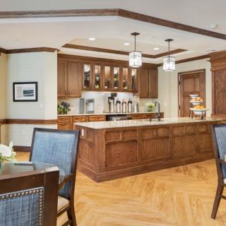 A modern kitchen with wooden cabinets, an island, and pendant lighting.