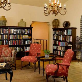 A cozy library with comfortable seating and shelves filled with books.