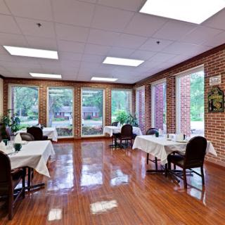 A bright and inviting dining area featuring neatly arranged tables and large windows that allow natural light to fill the space.