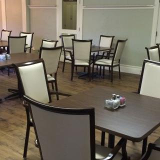 An empty dining room with neatly arranged tables and chairs.