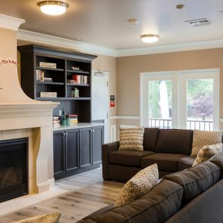 A cozy living room featuring a fireplace, modern decor, and comfortable sofas.