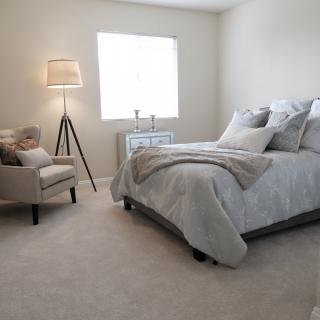 A minimalist bedroom featuring a cozy bed, neutral colors, and stylish decor.