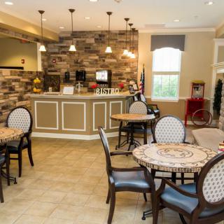 A cozy cafe interior with tables and chairs arranged near a counter.