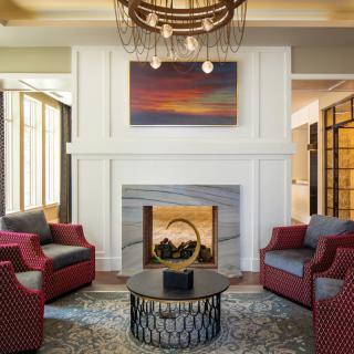 A modern living room featuring a fireplace, artwork, and comfortable seating.