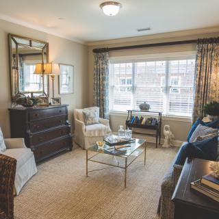 A cozy and elegantly decorated living room with ample natural light.